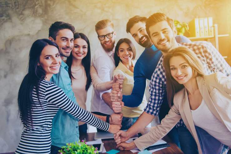 Colleghi di lavoro che uniscono le mani in segno di coesione di gruppo