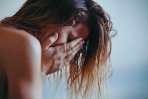 Donna in lacrime che si porta le mani sul viso