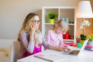 mamma che lavora da casa con accanto due bambine