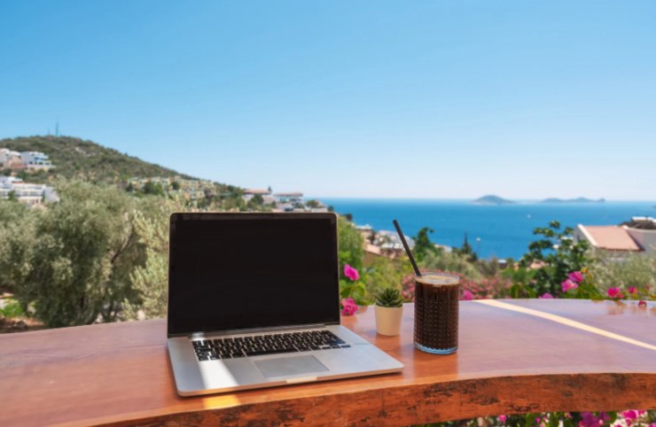 computer su un tavolo con dietro il mare