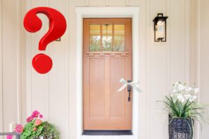 porta di casa con nastro bianco su maniglia e punto interrogativo rosso