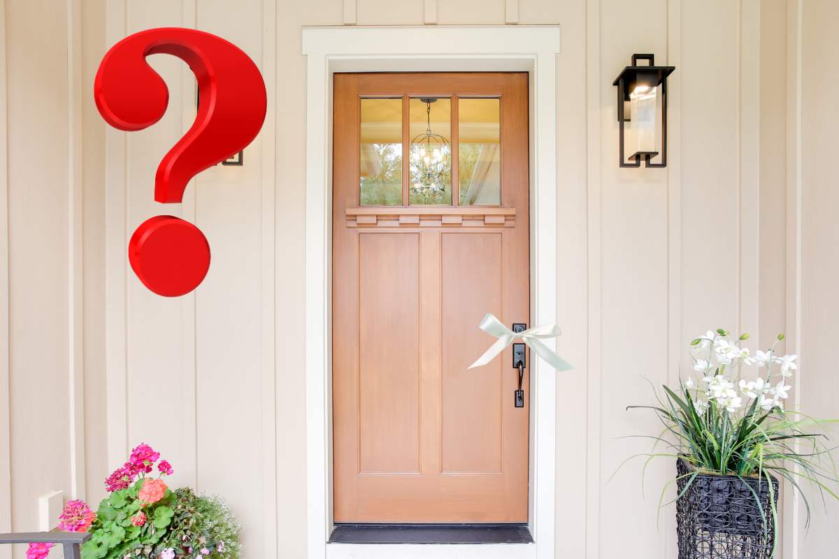 porta di casa con nastro bianco su maniglia e punto interrogativo rosso