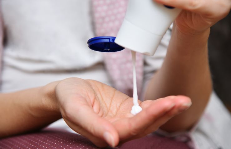 donna che mette crema sulle mani