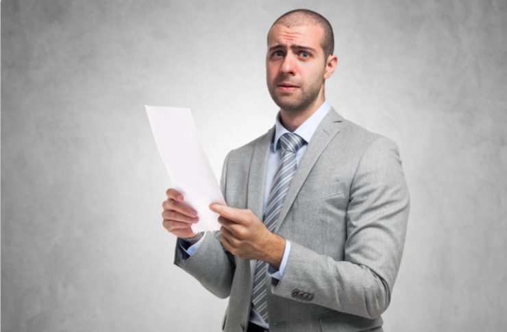 uomo preoccupato con un foglio in mano