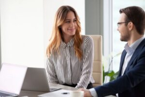 colleghi seduti vicino che si guardano e sorridono