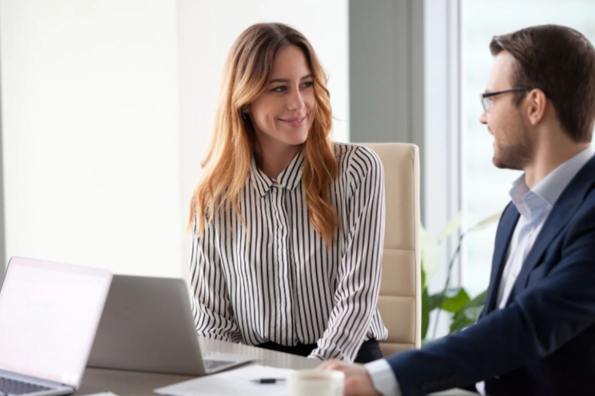 colleghi seduti vicino che si guardano e sorridono