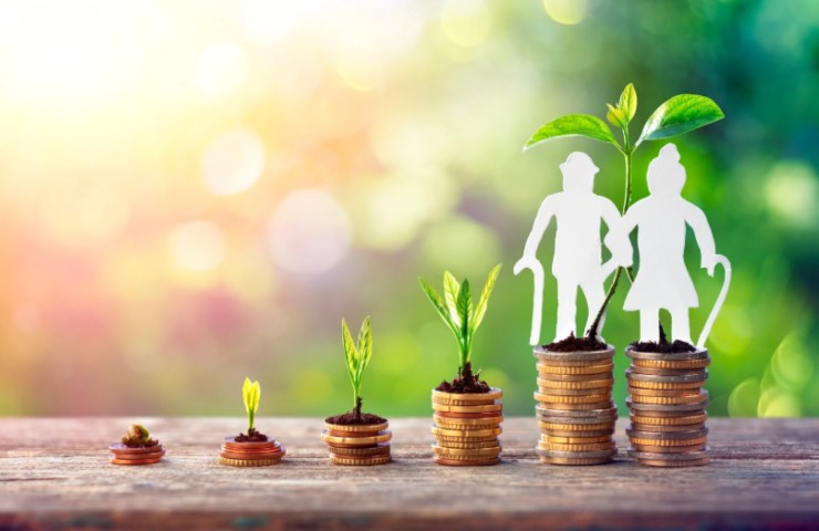 pile di monete e sagome di un uomo e una donna anziani