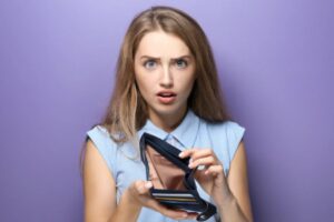 donna che tiene in mano un portafoglio vuoto