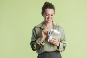 donna sorridente che conta delle banconote che ha in mano